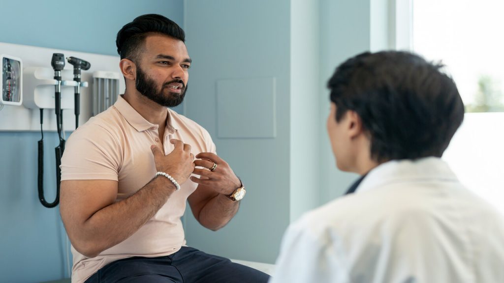Young Man In Consultation With Doctor
