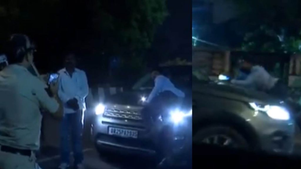 a person hanging on the car bonnet by a car driver